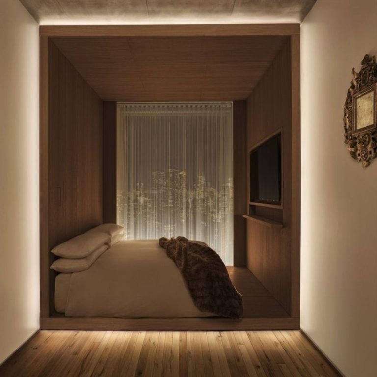 Linear LED lights edge lighting the sleeping are of a modern hotel bedroom. Boca Lighting and Controls