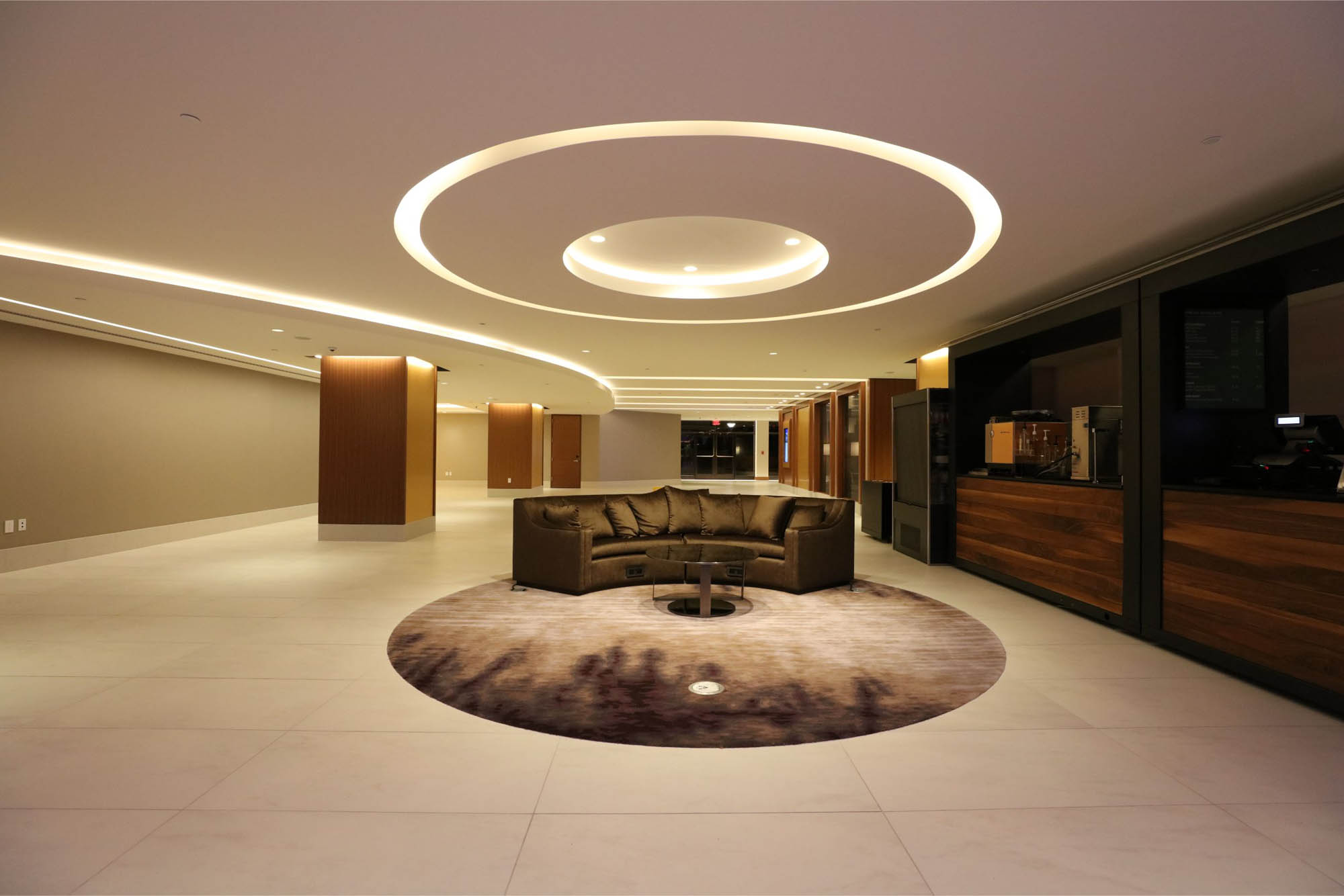 LED linear cove lighting accenting architectural ceiling elements in a hotel lobby. Boca Lighting and Controls
