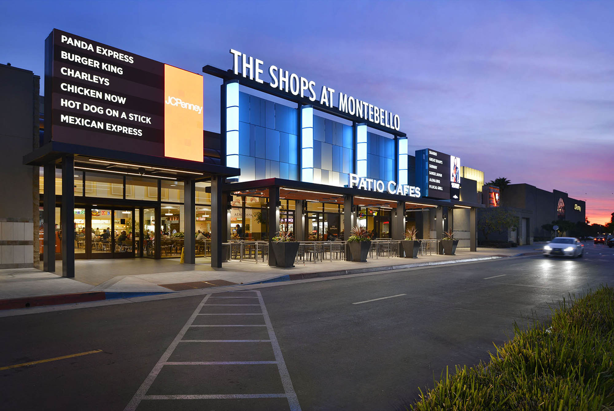 Blue LED linear strip lighting illuminating the exterior of The Shops at Montebello shopping center at dusk. Boca Lighting and Controls