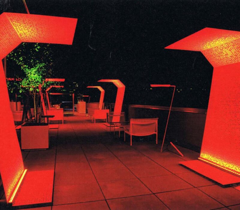 Wall washing and architectural accent lighting create a dynamic red color in an outdoor entertainment area.