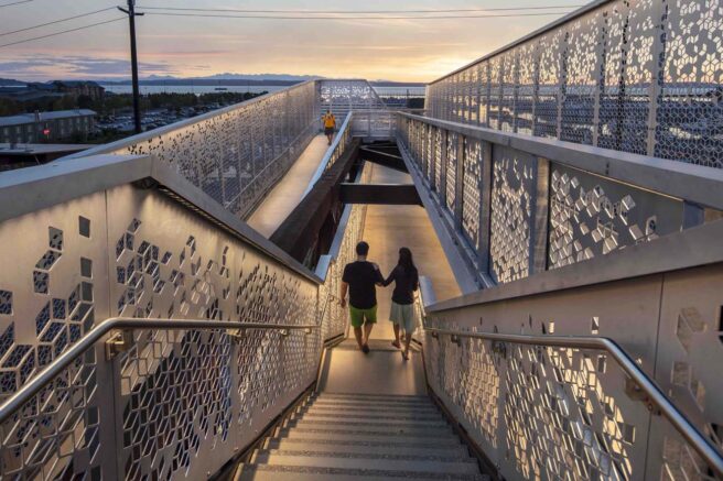 LED strip lights illuminate a pedestrian pathway and highlight the architecture on a bridge.