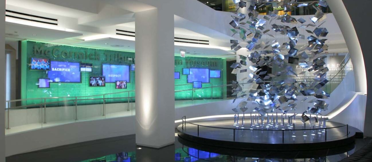 Linear LED cove lights accent architectural elements and artwork in a museum rotunda.