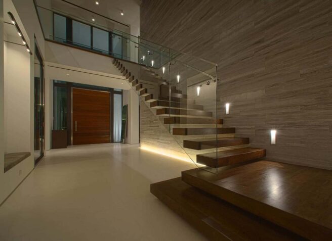 LED wall grazing and accent lighting in a residential entry foyer and staircase.