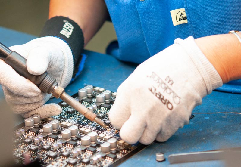 Close up image of a worker assembling electronic components