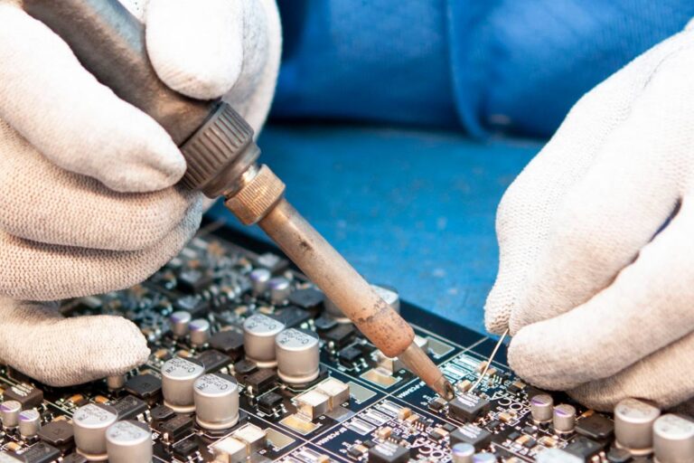 Close-up photo of a worker assembling electronic components on a lighting controls circuit board